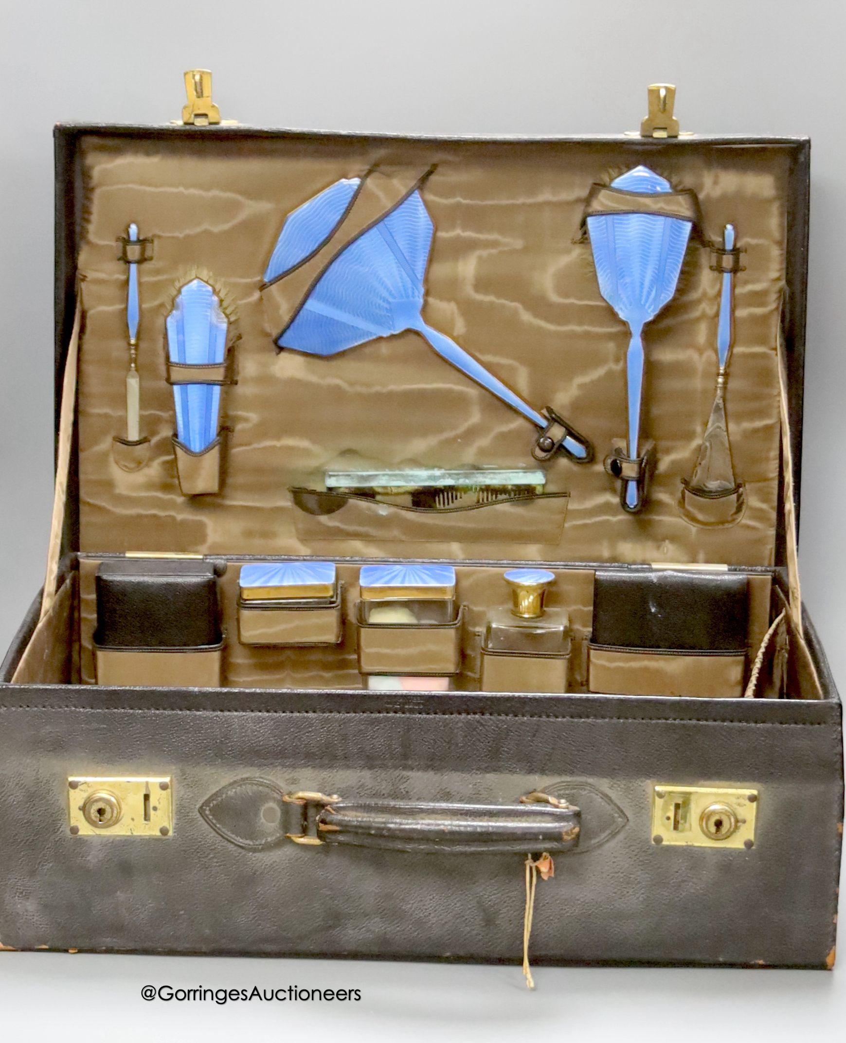 An early 20th century leather vanity case, with enclosed accessories and five further silver mounted vanity bottles